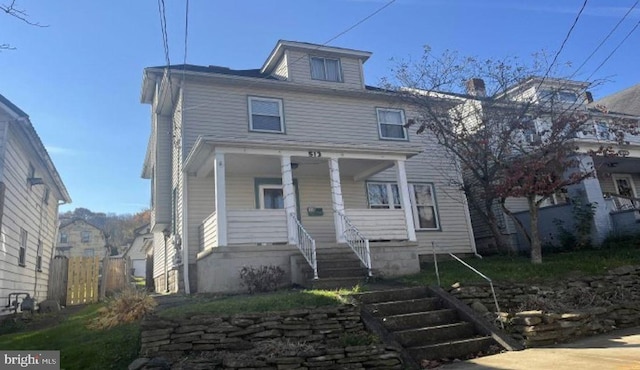 american foursquare style home featuring a porch