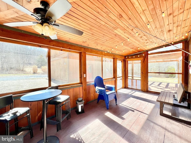 sunroom featuring vaulted ceiling, ceiling fan, and wooden ceiling