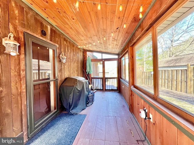 unfurnished sunroom featuring wooden ceiling and vaulted ceiling