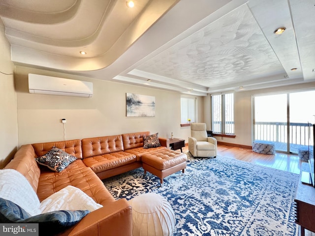 living area featuring an AC wall unit, wood finished floors, and a raised ceiling