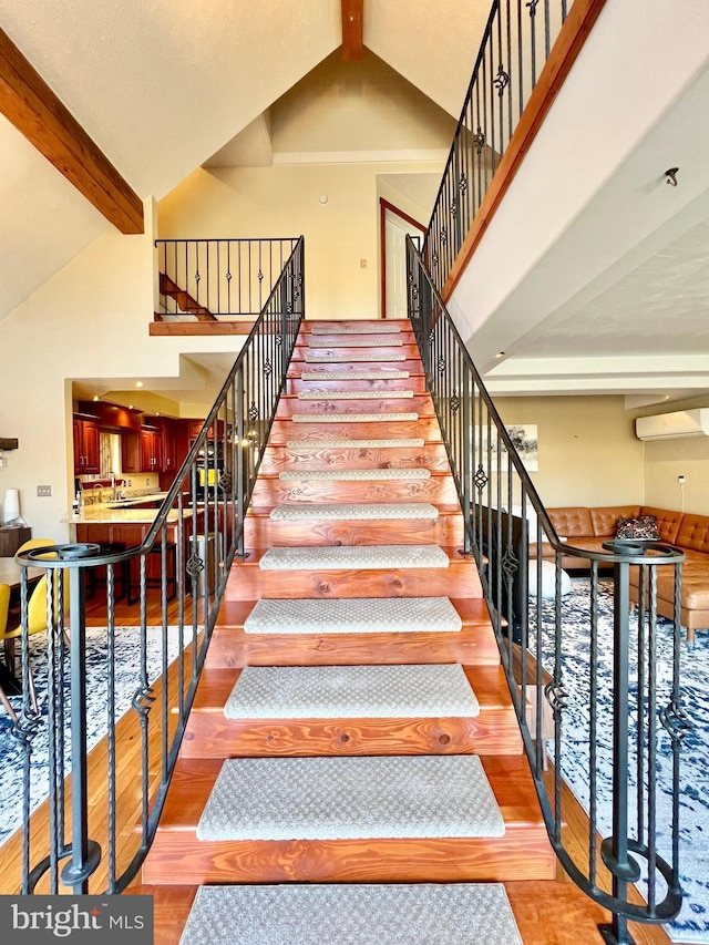 staircase featuring high vaulted ceiling, a wall mounted air conditioner, beamed ceiling, and wood finished floors