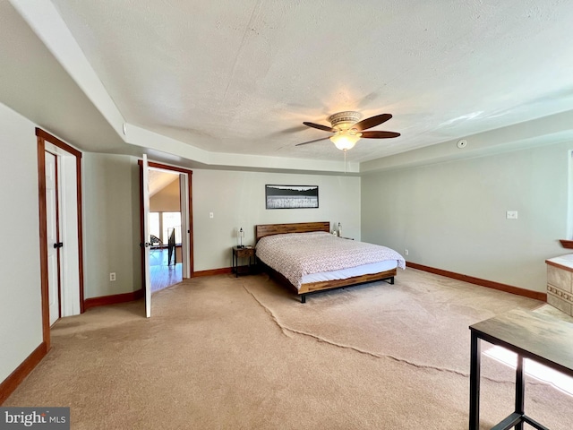 unfurnished bedroom with light carpet, a textured ceiling, and baseboards