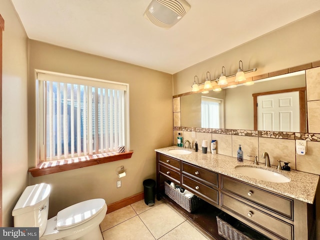 full bathroom featuring double vanity, a sink, toilet, and tile patterned floors