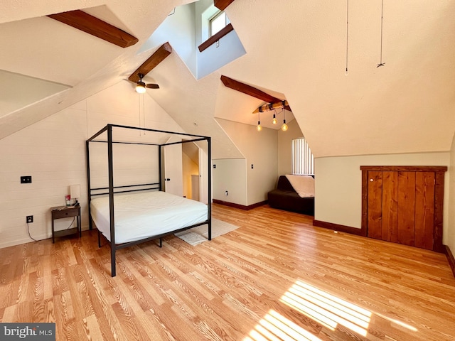 unfurnished bedroom with vaulted ceiling with beams, light wood-style flooring, and baseboards