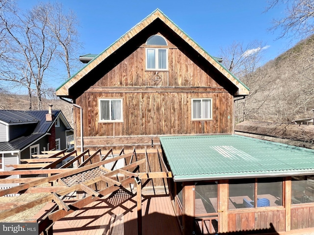 rear view of house featuring metal roof