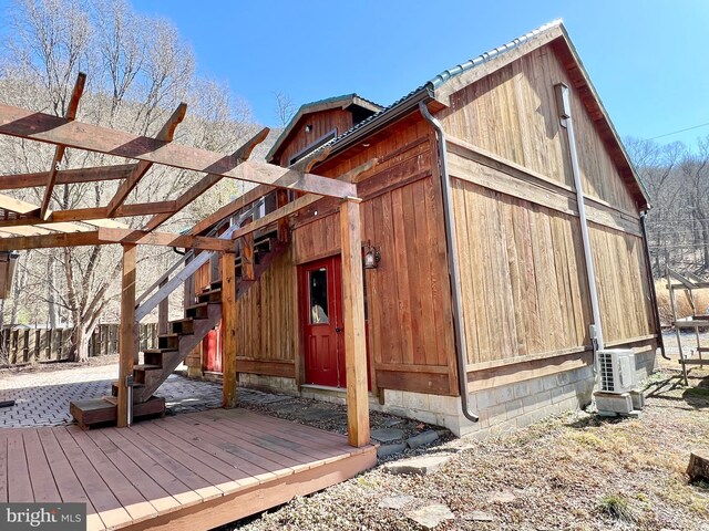 view of outdoor structure with ac unit and stairway