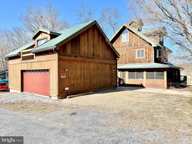 view of home's exterior with a garage and gravel driveway