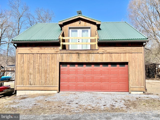 chalet / cabin featuring metal roof, a detached garage, and a tile roof