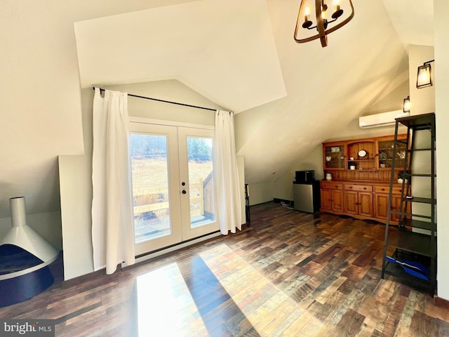 interior space with lofted ceiling, french doors, a wall mounted AC, and wood finished floors