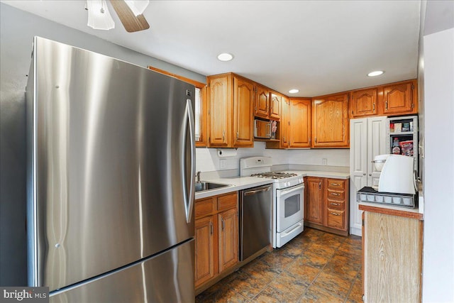 kitchen featuring appliances with stainless steel finishes, brown cabinetry, light countertops, and recessed lighting