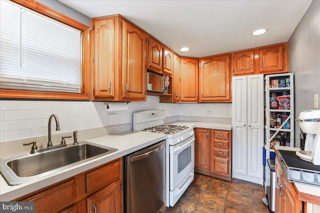 kitchen with dishwasher, light countertops, gas range gas stove, and a sink