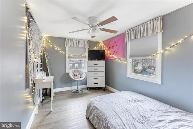 bedroom featuring ceiling fan, baseboards, and wood finished floors