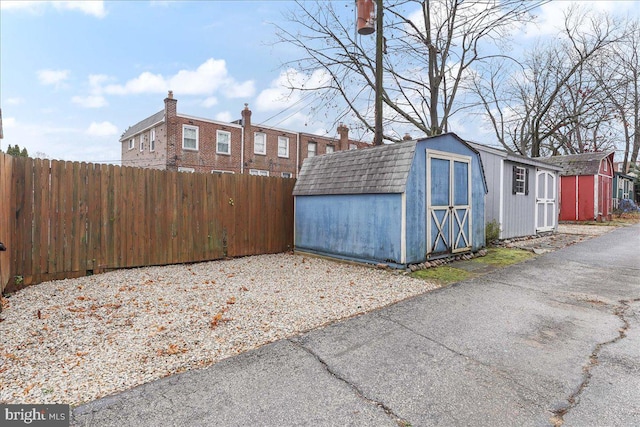 exterior space with fence and a shed