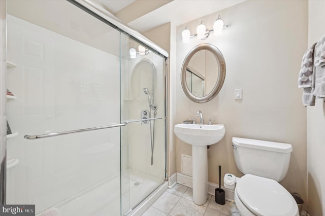 full bathroom featuring toilet, a stall shower, tile patterned flooring, and baseboards