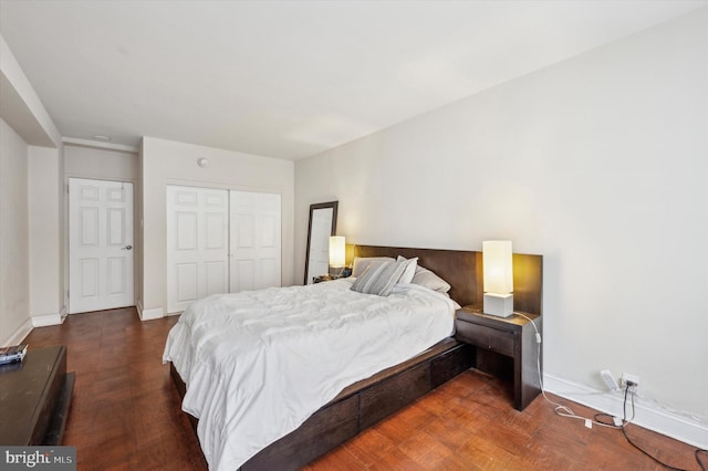 bedroom with baseboards, a closet, and wood finished floors