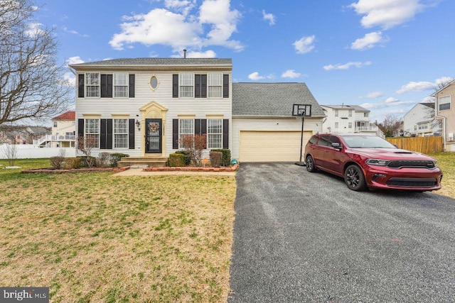 view of front of house featuring driveway, a front lawn, a garage, and fence
