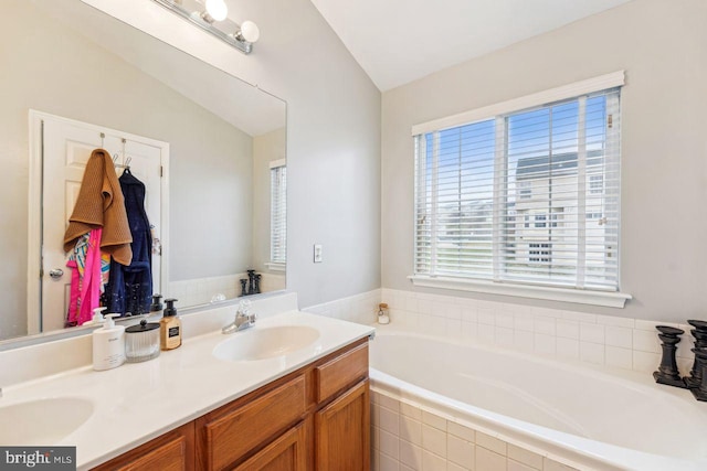 bathroom featuring a sink, a bath, and double vanity