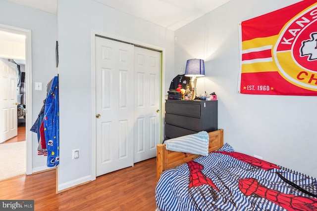 bedroom with a closet, baseboards, and wood finished floors