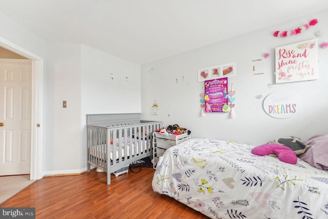 bedroom featuring wood finished floors and baseboards