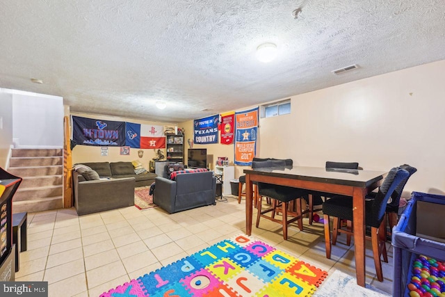 playroom featuring light tile patterned flooring, visible vents, and a textured ceiling