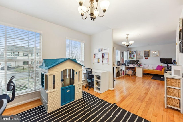 interior space featuring light wood finished floors, baseboards, and an inviting chandelier