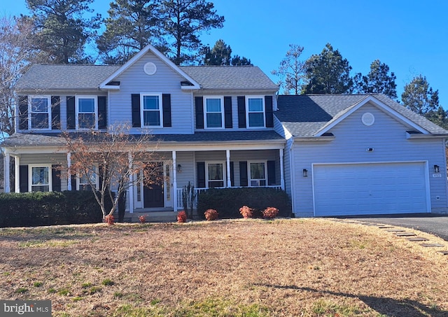 view of front facade with covered porch, a front yard, a garage, and a shingled roof