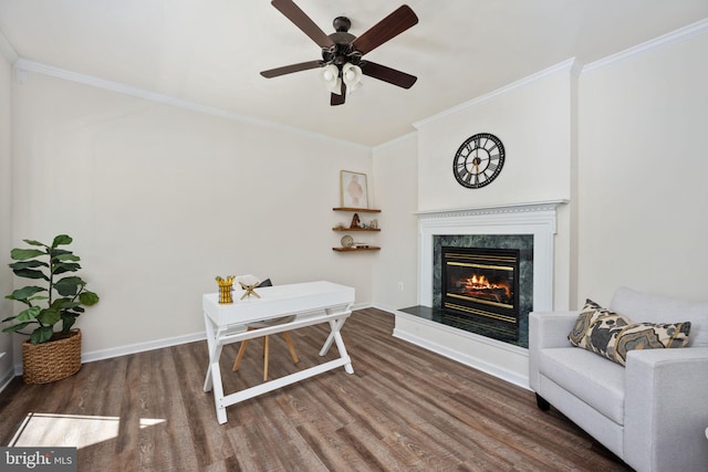 sitting room with a premium fireplace, ornamental molding, and wood finished floors