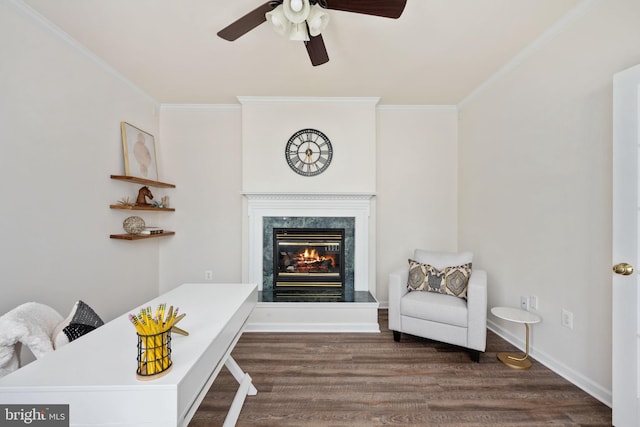 living area featuring dark wood-style floors, baseboards, a high end fireplace, ceiling fan, and ornamental molding