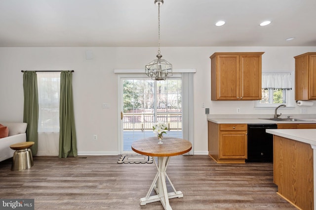 kitchen featuring dishwasher, light countertops, wood finished floors, and a sink