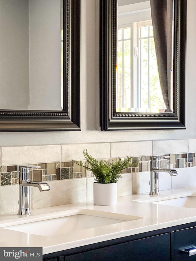 room details with tasteful backsplash, double vanity, and a sink