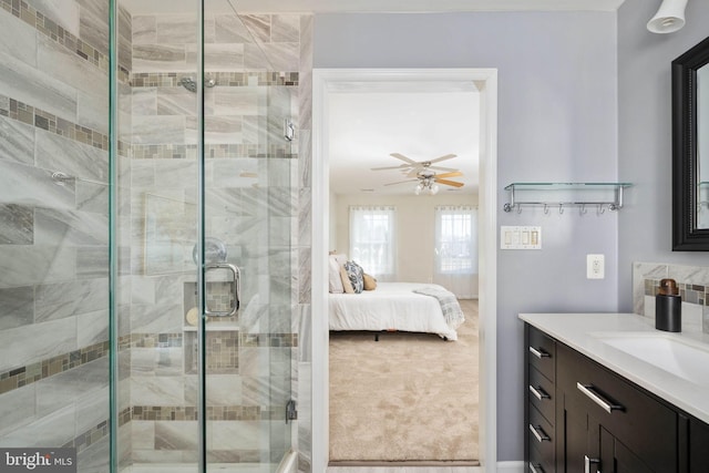 full bathroom with ceiling fan, vanity, a stall shower, and ensuite bathroom