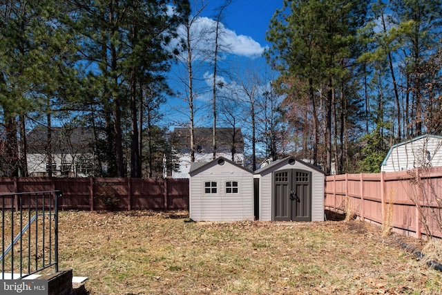 view of yard with a storage unit, a fenced backyard, and an outdoor structure