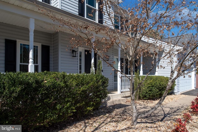 view of exterior entry with a garage and covered porch