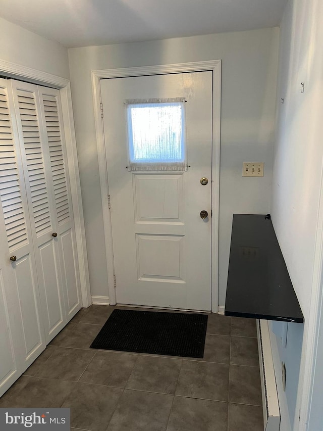 doorway with dark tile patterned flooring