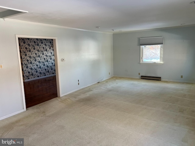 spare room with baseboards, ornamental molding, baseboard heating, and light colored carpet