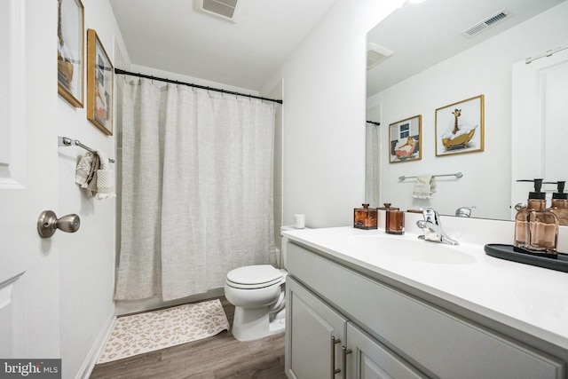 bathroom with visible vents, toilet, wood finished floors, and vanity