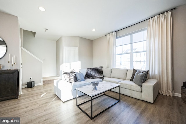 living area featuring recessed lighting, baseboards, and light wood finished floors