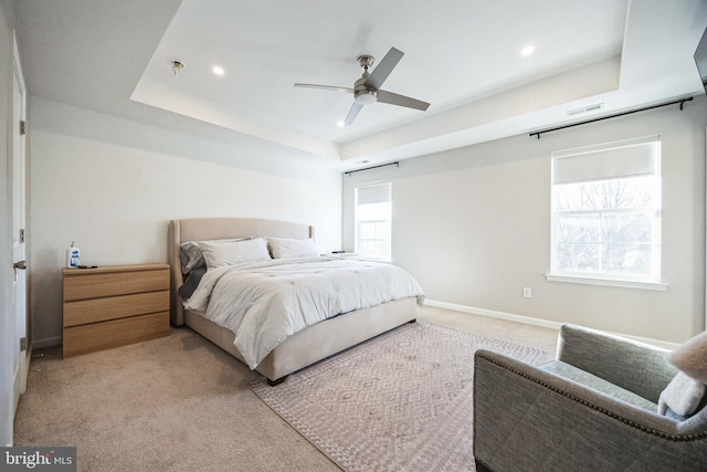 bedroom featuring visible vents, baseboards, a tray ceiling, recessed lighting, and light colored carpet