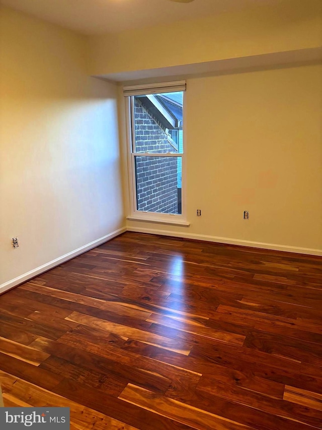 empty room featuring baseboards and wood finished floors