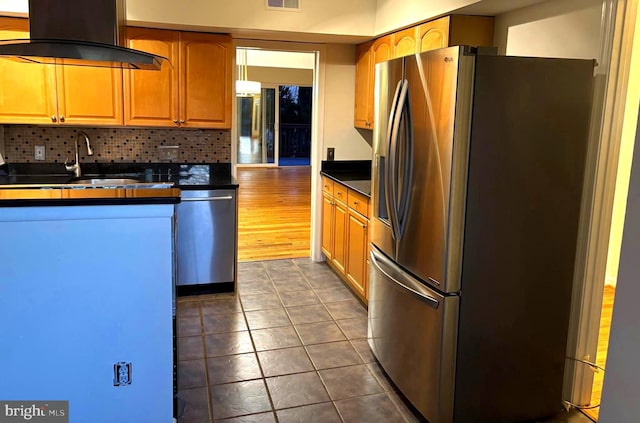 kitchen featuring stainless steel appliances, dark countertops, decorative backsplash, ventilation hood, and dark tile patterned floors