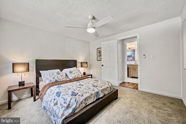 bedroom with a textured ceiling, ceiling fan, ensuite bathroom, carpet flooring, and baseboards