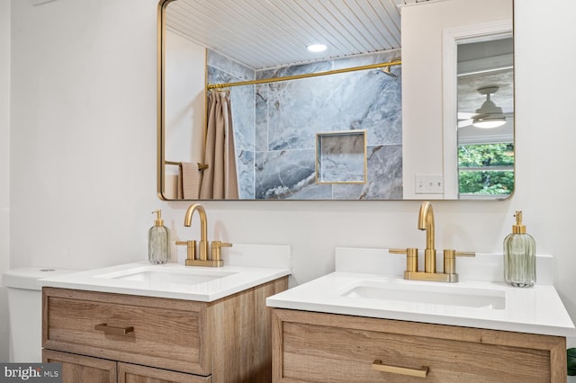 bathroom with curtained shower, two vanities, and a sink