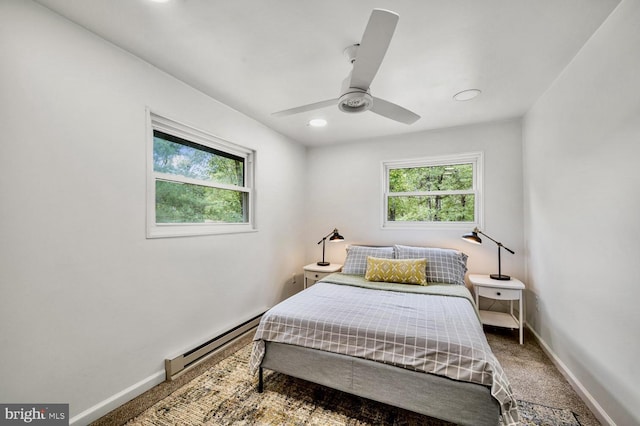 bedroom with a baseboard heating unit, carpet flooring, ceiling fan, and baseboards