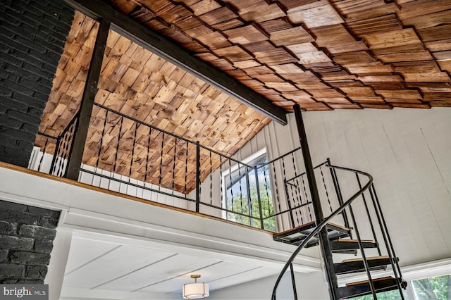 staircase featuring high vaulted ceiling, beamed ceiling, and wooden ceiling