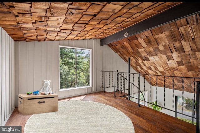 unfurnished room featuring wood ceiling, lofted ceiling with beams, an upstairs landing, and wood finished floors