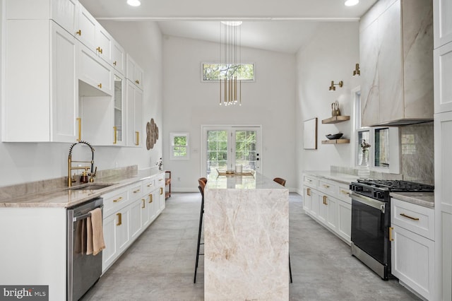 kitchen featuring white cabinets, custom exhaust hood, stainless steel appliances, and a sink