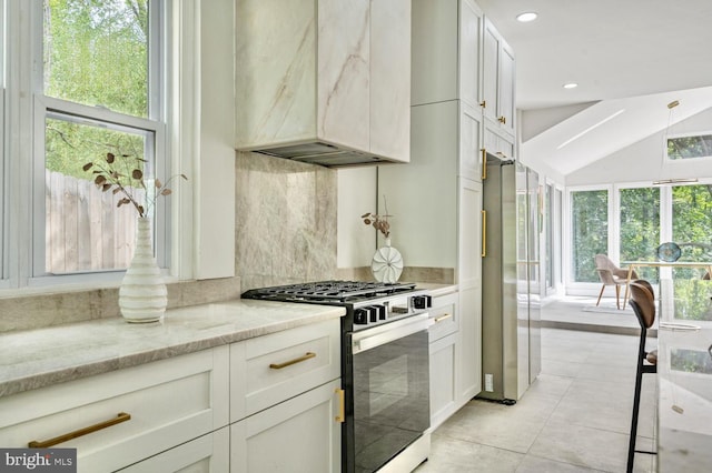 kitchen with a healthy amount of sunlight, appliances with stainless steel finishes, decorative backsplash, and light stone counters