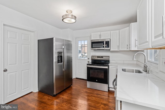 kitchen featuring a sink, stainless steel appliances, dark wood-style floors, and white cabinets