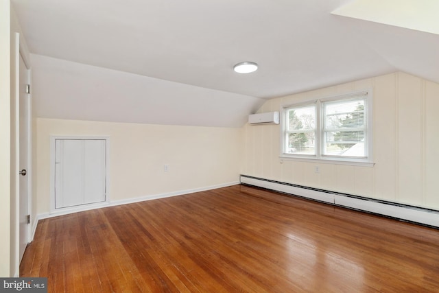 bonus room with lofted ceiling, a wall unit AC, wood-type flooring, and a baseboard radiator