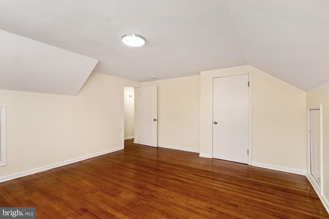 additional living space featuring vaulted ceiling, wood finished floors, and baseboards